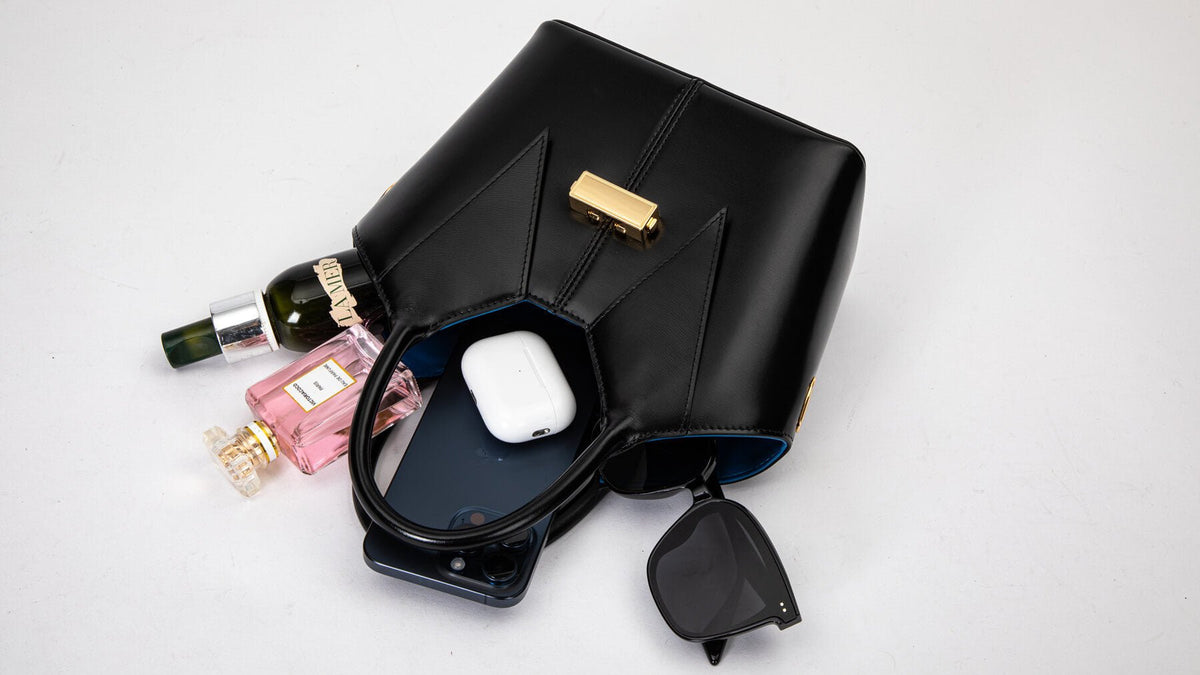A close-up of a woman's wallet, phone, and keys inside a bag